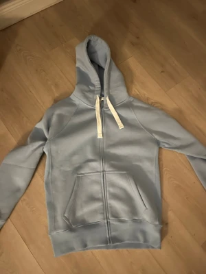 Ljusblå hoodie från Russemerch - Ljusblå hoodie från Russemerch med dragkedja framtill, helt oanvänd!