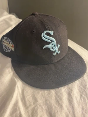 New era sox - Säljer en svart 59FIFTY keps från New Era med White Sox-logga i ljusblått framtill och patch på sidan. Undersidan av skärmen har ett unikt batikmönster i blått och vitt. Klassisk rak skärm och broderade detaljer gör den riktigt snygg. Hör av dig vid minsta fundering, pris går att diskutera vid snabb affär!