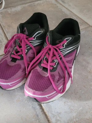 Lila sneakers från Everest - Snygga sneakers från Everest i lila mesh och syntetmaterial med svarta och vita detaljer. Skorna har rosa skosnören och en vit sula med svarta och rosa inslag. Perfekta för dig som gillar färg och sportig stil.