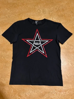 Hood By Air T-shirt svart  - Svart t-shirt från Hood By Air med stort stjärntryck i vitt och rött på bröstet. Klassisk rund halsringning och korta ärmar. Perfekt för dig som gillar streetwear och vill sticka ut med en grafisk detalj. Köpte ganska nyss så detta är mest en intresse koll skriv gärna vid frågor/köp! Är osäker på om jag vill sälja så pris får diskuteras privat! Btw jag är 188cm som referens 