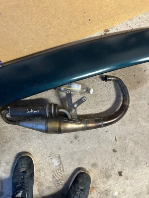 Leovince avgassystem till moped - Säljer ett Leovince avgassystem till moped. Systemet är i metall med svart ljuddämpare och har en böjd form. Passar bra för dig som vill uppgradera ljudet och prestandan på din moppe.