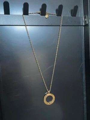 Guldfärgat halsband med cirkelberlock - Snyggt halsband i guldfärg med en rund cirkelberlock där det står 'BELIEVE IN YOURSELF'.  vet ej märket 