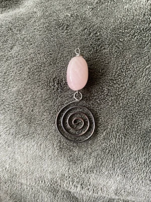 berlock med rosenkvarts och spiral - Berlock med spiral och stenen rosenkvarts. Rosenkvarts är känd för att vara kärlekens sten men den fokuserar faktiskt främst på att man ska älska sig själv. Rosenkvarts står även för balans, lugn, harmoni och självförtroende. Jag har två likadana berlocker som man ser på bilderna. En berlock säljer jag för 60 kronor och båda två för 100 kronor. Om man vill köpa två för 100 kronor så får man höra av sig till mig så ändrar jag priset på artikeln till 100 kronor.