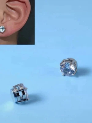 Silvriga örhängen med klar sten - Säljer ett par stilrena örhängen i silverfärg med rund, klar sten som gnistrar snyggt. Klassisk design som passar till allt och ger en fräsch look. Kommer i en liten plastask. Perfekt för dig som gillar enkel men elegant stil.