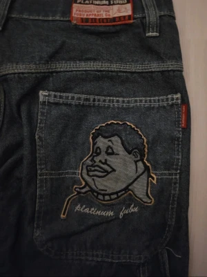 Vintage denim FUBU shorts - FUBU Platinum jorts, broderad ansikte och text 'Platinum FUBU' på bakfickan. De är vintage, inte slitet någon stans på utsidan och är knappt använda. De har kontrastsömmar och perfekt för streetwear, drainer, eller skater stil! Jag tror att de är storlek för män men inte säker, kanske unisex. Meddela mig ifall om du har någon fråga 🫶🏻