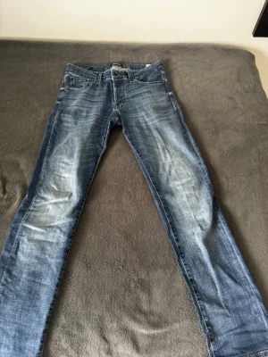 Jack and Jones Glenn - Säljer ett par klassiska blå jeans med raka ben och snygga slitningar framtill. Jeansen har fem fickor och normal midja. Perfekta för en avslappnad och trendig look. Materialet är denim i bomull som ger en skön känsla hela dagen. 30/32