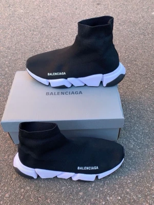 Balenciaga Speed Trainer svarta sneakers - Svarta Balenciaga Speed Trainer sneakers med vit chunky sula och stickad ovandel i textil. Strump-liknande passform och logga på sidan. Snygg och futuristisk design som sticker ut.