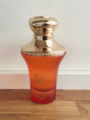Anhaar Dune parfym från Zimaya - Anhaar Dune från Zimaya är en parfym i en elegant bärnstensfärgad glasflaska med guldfärgat lock. Doften har tydliga inslag av vanilj, sötma, amber, karamell och citrus. Flaskan har en lyxig och unik form som sticker ut på parfymhyllan.Använt högst 10 %