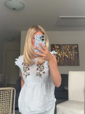 Vit blus med broderade blommor - Säljer min super söta blus! Passar så bra till vår och sommar💗