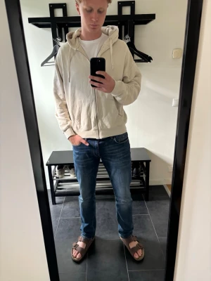 Beige zip hoodie - Säljer ett par blå jeans med rak passform och normal midja. Jeansen har klassiska fem fickor och är tillverkade i denim med lätt tvättad look. Perfekta för dig som gillar en enkel och tidlös stil. Passar till det mesta och är riktigt bekväma.