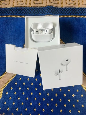 Apple AirPods Pro 2 USB-C - Säljer ett par vita Apple AirPods Pro 2nd generation med MagSafe-laddningsetui och USB-C. Trådlösa in-ear hörlurar med silikontoppar och aktiv brusreducering. Kommer i originalförpackning med tillbehör. Perfekta för musik, poddar och samtal.