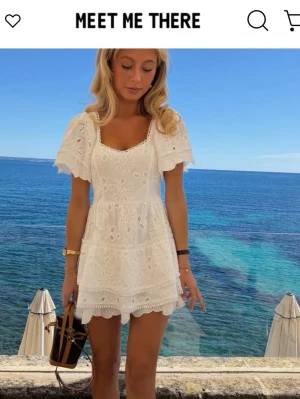 Meet Me There klänning vit - Meet Me There ”Lover lace” klänning i vit. Kort vit klänning med broderade spetsdetaljer och volanger. Storlek S/M. Använd vid ett tillfälle, kemtvättad därefter. 