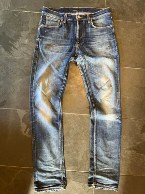 Nudie jeans Lean Dean - Säljer ett par riktigt feta jeans från Nudie. Jeansen har sjukt snygga slitningar/fades och har riktigt snygg passform. De är i storlek W31 L32. Måtten är: Ytterben: 107cm, innerben: 78cm, midja: 43cm, Benöppning: 17cm