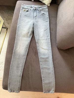 Ljusblå skinny jeans - Säljer ett par ljusblå skinny jeans med klassisk femficksdesign och dragkedja. Jeansen har en smal passform och är tillverkade i stretchigt denimtyg för extra komfort. Perfekta till en avslappnad och trendig look.
