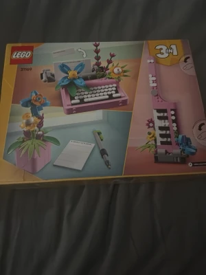 LEGO 3-i-1 skrivmaskin och blommor - Säljer ett LEGO-set  där du kan bygga en rosa skrivmaskin med blommor, en blomkruka eller en annan kreativ modell. Setet har färgglada delar i rosa, blått, grönt och vitt. Perfekt för dig som gillar att bygga och vill ha något dekorativt till rummet. Är oöppnad