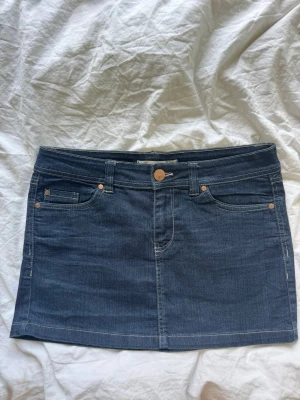 Vintage jeanskjol - Midja tvärsöver: 42 cm. Lågmidjad. Längd: 33 cm