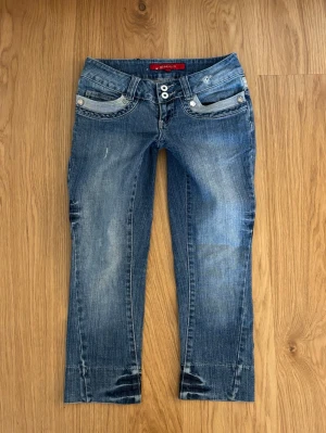 Supersnygga trekvartsjeans  - Säljer ett par super snygga trekvarts längd  jeans som för längesen såldes på GinaTricot. Jeansen är lågmidjade och har dubbla knappar o midjan och de har även har en super fin tvätt och snygga detaljer i fram och på bakfickorna.🥰 