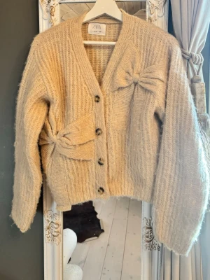 Beige kofta med rosetter från ZARA - Mysig beige kofta från ZARA från barnavdelningen i storlek 164 men passar bra på mig som har s/xs😇