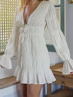 Vit klänning  - Vit volangklänning med knyte strax under bysten, knytena går att justera för att göra mindre eller större. (Sitter som en L, men passar även M och XL då knytena kan justeras och tyget är stretchigt)