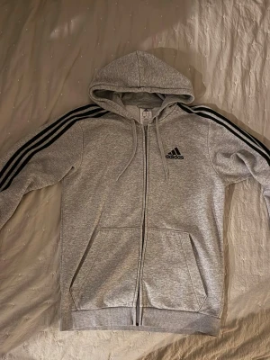 Adidas zip hoodie - Säljer denna zip hoodie från adidas i ett fint skick. Den är sparsamt använd och inga defekter. Storlek S. Hör av er vid funderingar!