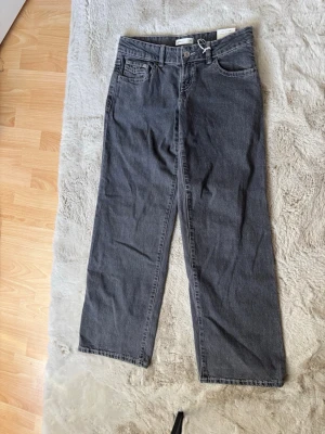 Grå ultra low wide jeans 36 - Säljer ett par gråa ultra low wide jeans från Ginatricot i storlek 36, aldrig använda då de ej passa mig.
