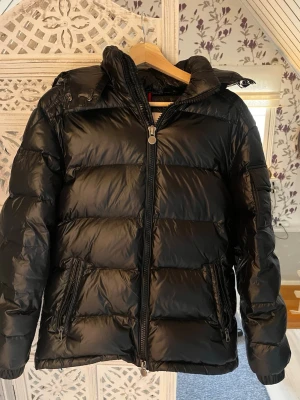 Dunjacka från Moncler  - Dunjacka från moncler storlek S men känns mer som en större M, säljer då den är lite för stor för mig och den inte kommer till användning. Inga fläckar bara märket ”Moncler ” som är lite utnött på dragkedjan 