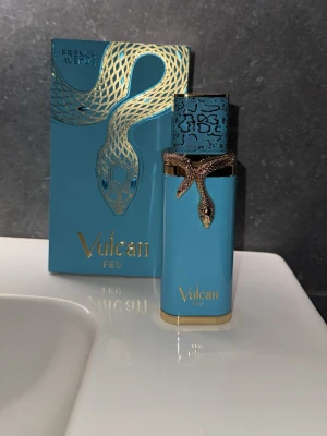 Vulcan Feu parfym 100ml - Exklusiv parfym från French Avenue, Vulcan Feu, i en lyxig turkos flaska med gulddetaljer och en dekorativ orm runt halsen. Flaskan rymmer 100ml och har ett unikt mönstrat lock. Kommer i matchande presentförpackning.