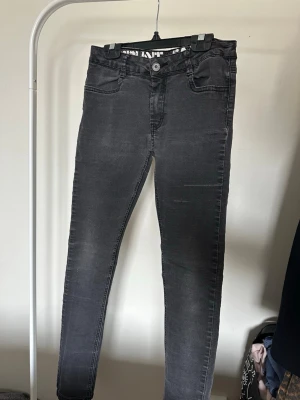 Grå slim fit jeans med stretch - Säljer ett par grå slim fit jeans med snygg tvätt och klassiska femficksdetaljer. Jeansen har stretchigt material som gör dem bekväma och sitter tight hela vägen ner. Perfekt för dig som gillar en modern och stilren look.