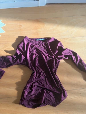 Vinröd långärmad topp från 157 - En enkel och stilren vinröd långärmad topp från 157. Toppen har rund halsringning och är gjord i mjuk bomull som känns skön mot huden. Perfekt att matcha med jeans eller kjol för en clean look.