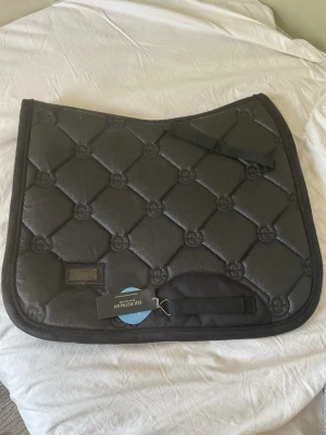 Svart glittrigt schabrak från Equestrian stockholm  - PRIS GÅR ATT DISKUTERA Säljer ett svart schabrak från Equestrian Stockholm med glittrig finish och quiltat mönster'. Aldrig använt och har till och med lappen kvar. Man får också med två fina benlindor på köpet som också aldrig är använda från Equestrian Stockholm 