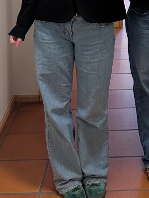 Ljusblå populära raka wide jeans från NAKD - Säljer ett par ljusblå jeans med rak passform och låg midja från NAKD. Jeansen har klassisk femficksdesign och stängs med dragkedja och knapp. Perfekta för en avslappnad och trendig look. Något slitna lägst ner i bak, jag är 175 för referens💗