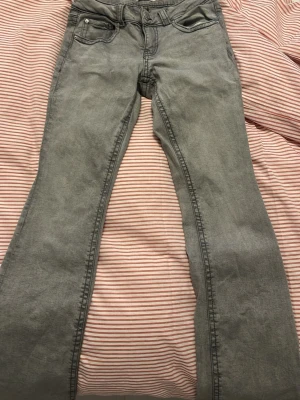 Grå bootcut jeans från Perfect Jeans - Snygga grå jeans från Gina tricot som är låg midjade och använda ett par få tal gånger.