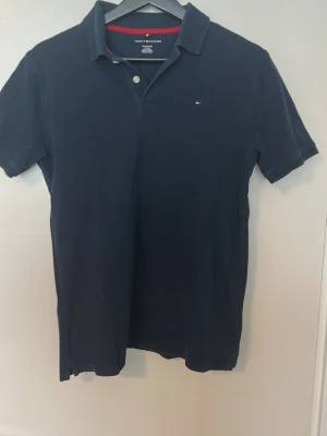 Marinblå pikétröja Tommy Hilfiger - Klassisk marinblå pikétröja från Tommy Hilfiger, storlek XL (16-18) sitter XS-S herr 