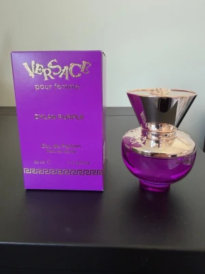 Versace Dylan Purple Eau de Parfum 30 ml  - Säljer Versace Dylan Purple 30 ml. Endast testad med några få sprayningar, så nästan hela innehållet finns kvar. En söt, fruktig och feminin doft med en fräsch känsla. Perfekt för dig som gillar en ungdomlig och lättburen parfym som passar både till vardags och speciella tillfällen. Se bilder för skick.