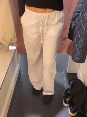Linnebyxor - Gina Tricot  - Vita linnebyxor från Gina tricot. Bra skick, förutom att de har en liten osynlig defekt, vilket är att de har blivit trasiga/ slitna längst ner på byxorna pga. att de har varit för stora på mig. Går lätt att klippa bort eller sy, syns absolut inte heller!
