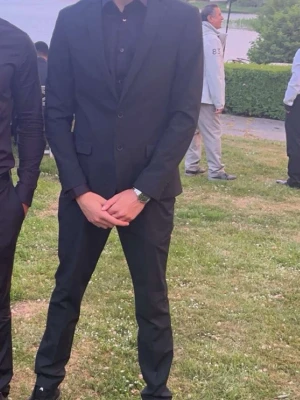 Svart kostym med kavaj och byxor - Säljer en klassisk svart kostym med matchande kavaj och byxor. Kavajen har knappar framtill och en stilren passform. Perfekt för dig som vill ha en enkel och snygg look. Skjorta ingår  ifall du vill ha den. Allting är använda 1 gång och passar bra till studenten och baler! Kavajen har storlek 50R Slim Fit. Byxorna har storlek 33-32 Slim Fit