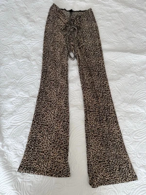 Leopardmönstrade leggings från SHEIN - Säljer ett par leopardmönstrade leggings från SHEIN med snörning framtill. De har utsvängda ben och är gjorda i ett mjukt, stretchigt material. Storlek S. Perfekta för dig som vill sticka ut med ett djurmönster och gillar trendiga detaljer. Aldrig haft på mig. 