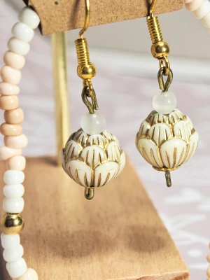 Handgjorda örhängen med pärldetaljer - Unika örhängen  med stora vita pärlor i lotusliknande form och guldfärgade detaljer. Örhängena har även små vita pärlor upptill och hängs på guldpläterade krokar. Matchande enkelt armband ca 17 cm långt. Perfekta för dig som gillar boho och handgjorda accessoarer.