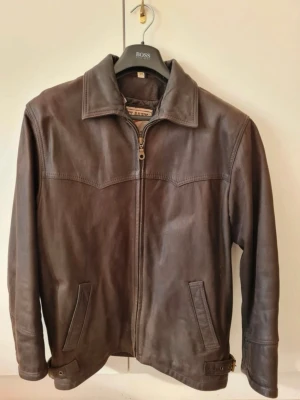 Jacka i äkta skinn, storlek 50, Herr, Sky Hawk - Läder jacka har köpts i Grekland, helfodrad. Jackan har två stycken inne fickor, en av de med dragkedja. Kan hämtas i Vallentuna.