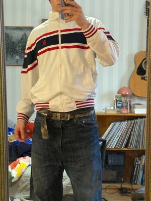 Vit Track Top - Säljer en Vit track top med blåa och röda detaljer. Den är i fint skick och har använts sparsamt. 