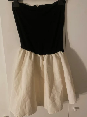 Svartvit axelbandslös kortklänning - Snygg axelbandslös klänning.  Passar S och M.