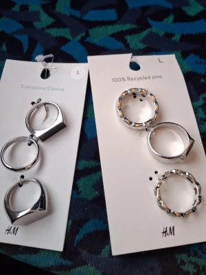 2 pack ringar från hm 10kr styck  - Säljer två par coola örhängen från H&M i silverfärg. Ena paret har en chunky, slät design medan det andra paret har en rundad form med nitar runt om. Båda paren är i metall och ger en trendig vibe till din look. Original pris är 40kr per