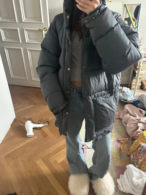 Svart/ mörkt blå pufferjacka från Fjällräven - Säljer en svart, oversized pufferjacka från Fjällräven med hög krage och stora fickor framtill.  Jackan har dragkedja och tryckknappar. Dock dragkedjan är sönder, men kan säkert gå och fixa om man lämnar in den. Lite gammal men inte så jätte använd har mest bara suttit i förråd!  Perfekt för kalla vinterdagar och riktigt mysig att bära.❣️ 