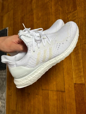 Adidas ultraboost sällsynta - Ett par vita Adidas UltraBoost sneakers som släpptes 2017. Perfekt för löpning eller vardagsbruk. Bekväma och stilrena. Endast använda 1 gång!  Ovandelen i cashmere ull. Premium skor och ett fantastiskt samarbete mellan A Ma Maniere, Adidas och Invincible.  Kommer även med original kartong  Storlek 40 men passar mer 39.5