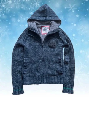 Mörkgrå stickad hoodie fodrad - Snygg mörkgrå stickad hoodie med dragkedja och mjukt grått foder på insidan. Har ett broderad 48-märke på bröstet. Storlek S. Perfekt för kalla dagar och riktigt skön att ha på sig. Skriv om du har några frågor! Priset går att diskutera!