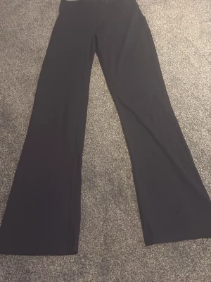 Svarta utsvängda byxor Firefly - Säljer ett par svarta utsvängda byxor från Firefly. Byxorna har hög midja och vida ben, vilket ger en snygg siluett. Perfekta till sneakers eller boots. Materialet känns mjukt och stretchigt för extra komfort.