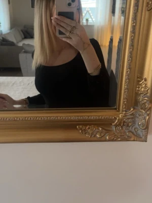 Svart croppad långärmad topp - Säljer en svart croppad topp med långa ärmar och rundad halsringning. Toppen har en tight passform och är perfekt för att styla med höga jeans eller kjol. Enkel och stilren design som passar till många olika looks.