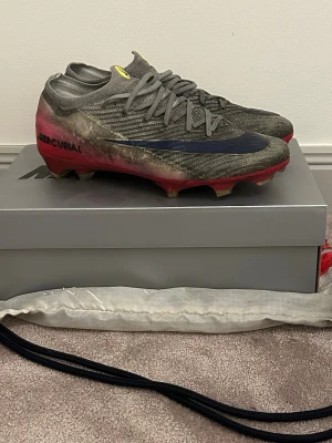 Nike Mercurial röda fotbollsskor - Säljer ett par Nike Mercurial fotbollsskor! Dem är i storlek 42,5. Fotbollsskorna fungerar helt perfekt, dem är lite färgade men går att rengöra! Annars helt perfekta fotbollsskor. Nypriset är 3200kr och säljer för endast 499kr!! Riktig steal, vill bara få bort dem så priset kan sänkas något. Jag säljer dem för att dem har blivit för små. Du får med box och bagen till skorna. Skriv till mig vid frågor och minsta intresse!😄