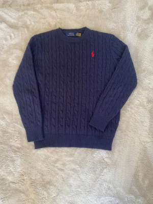 Kabel stickad Ralph Lauren tröja - Ralph Lauren kabel stickad tröja i marinblå, strl M. Mycket bra skick men lite nopprig. Nypris är 2099kr. Postar inom 24h📦 köp minst två plagg för 20% rabatt🤝 Tveka inte på att höra av er vid frågor eller funderingar!