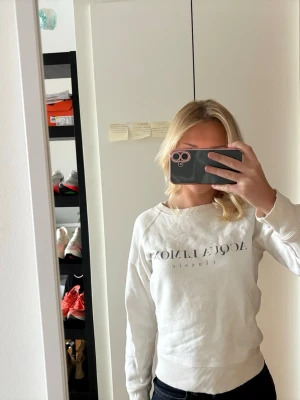 Vit sweatshirt från Acqua Limone - Säljer en vit sweatshirt från Acqua Limone med tryckt logga på bröstet. Tröjan har rund halsringning, ribbade muddar vid ärmslut och nederkant samt en avslappnad passform. Perfekt för en chill och stilren look.